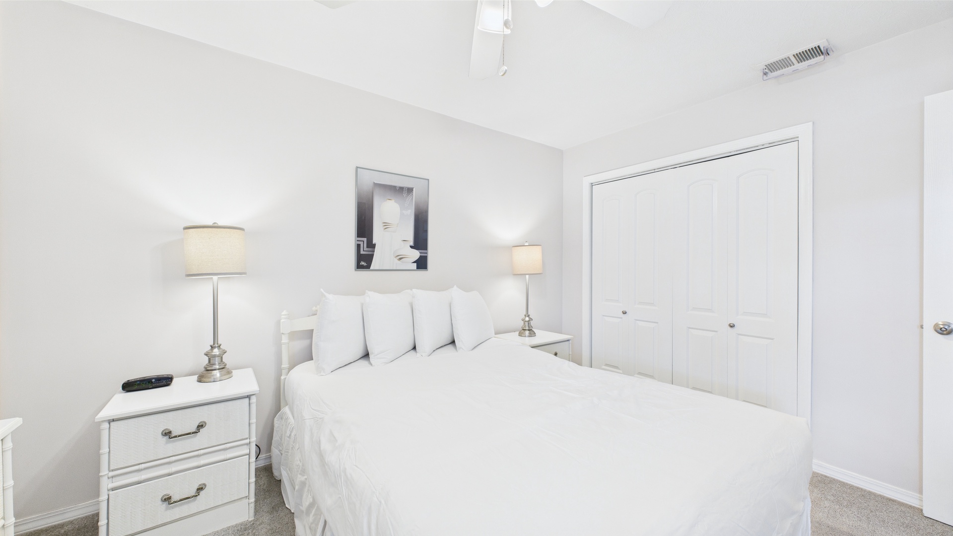 Primary bedroom with queen bed TV and balcony access