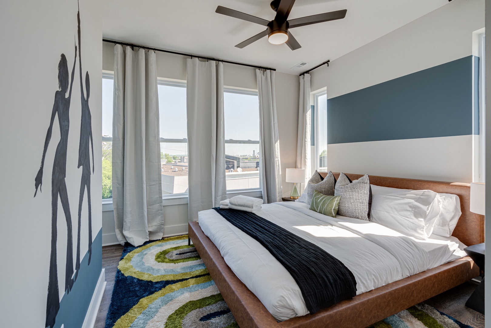 2nd bedroom with King bed, designer furnishings, mural, walk-in closet, and en-suite bathroom.
