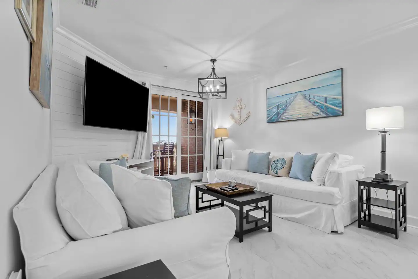 Open concept living area with stylish furnishings balcony access and sofa bed