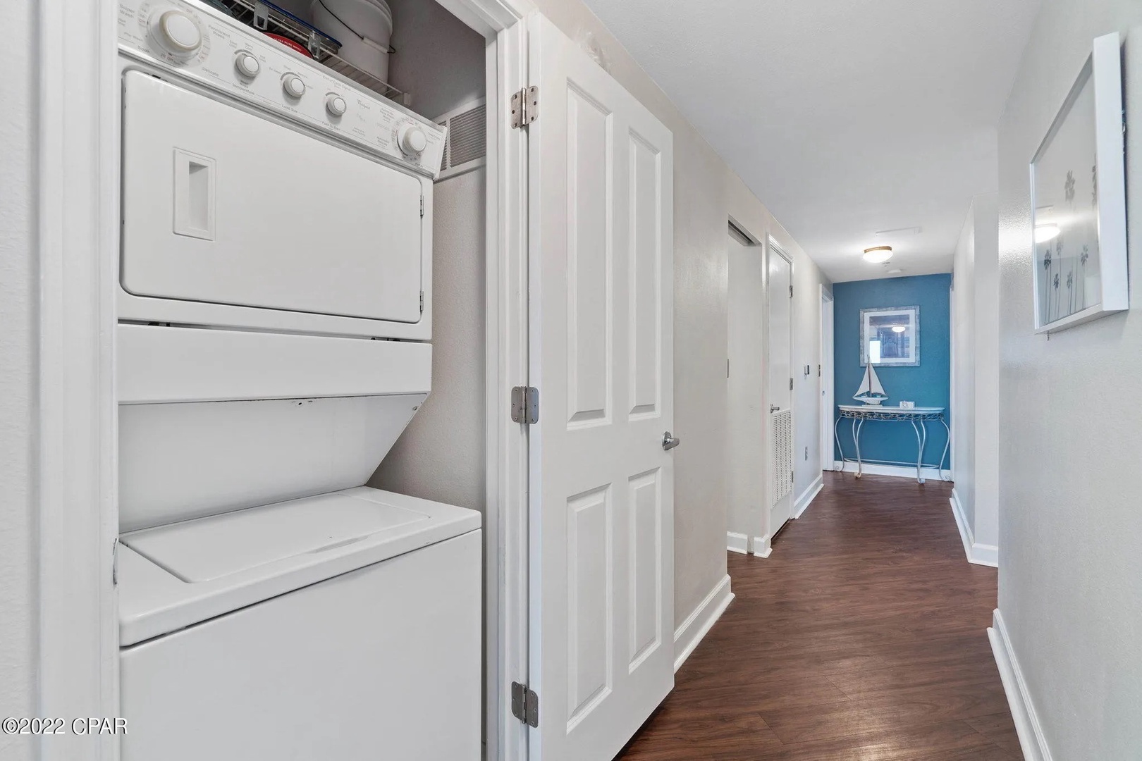 Washer and dryer unit in hallway leading to bedrooms.