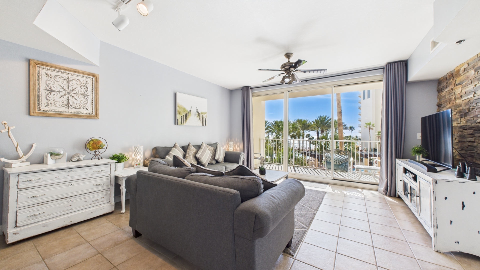 Open concept living area with sleeper sofa TV and balcony access