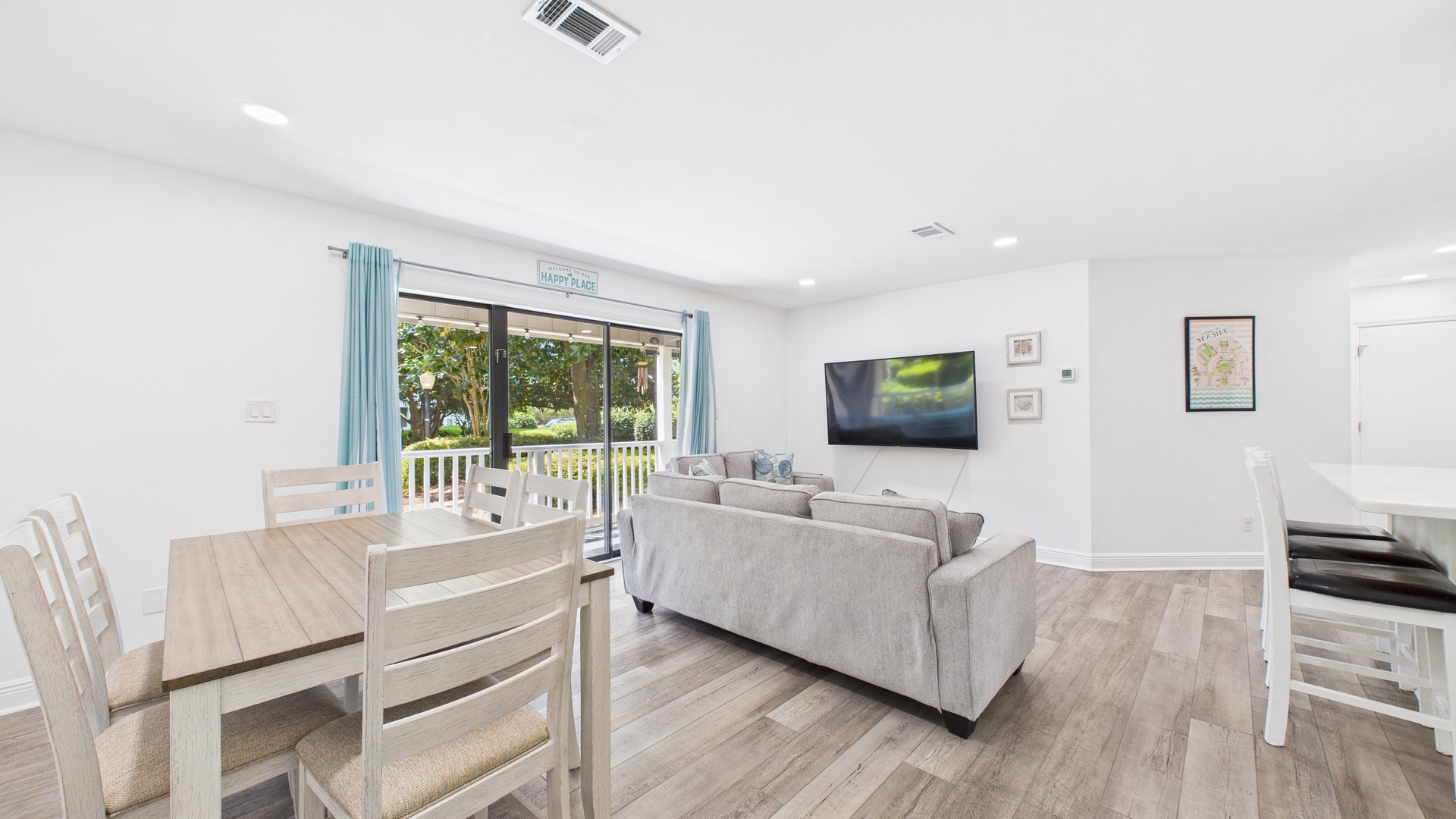 Open concept living area with huge TV and sleeper sofa