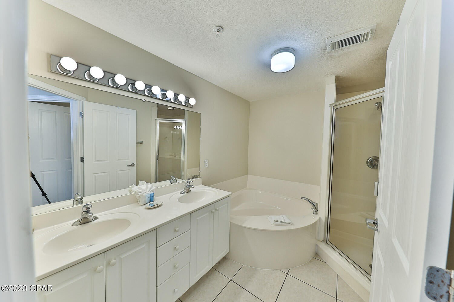 Primary bathroom with dual vanity bathtub and walk in shower