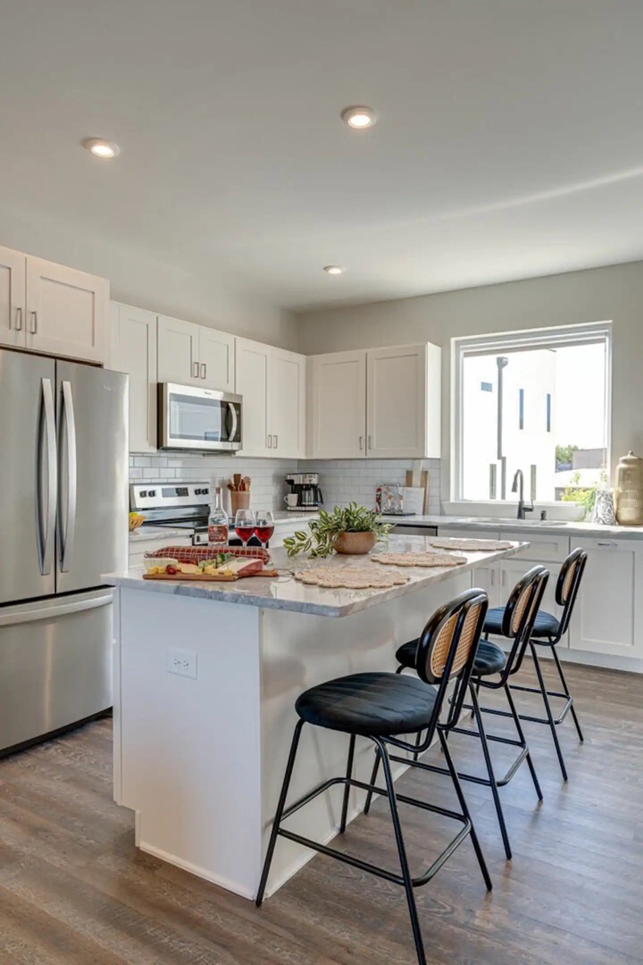 5629 - Open kitchen with stainless steel appliances, large island, breakfast bar seating, and is fully equipped with your basic cooking essentials.