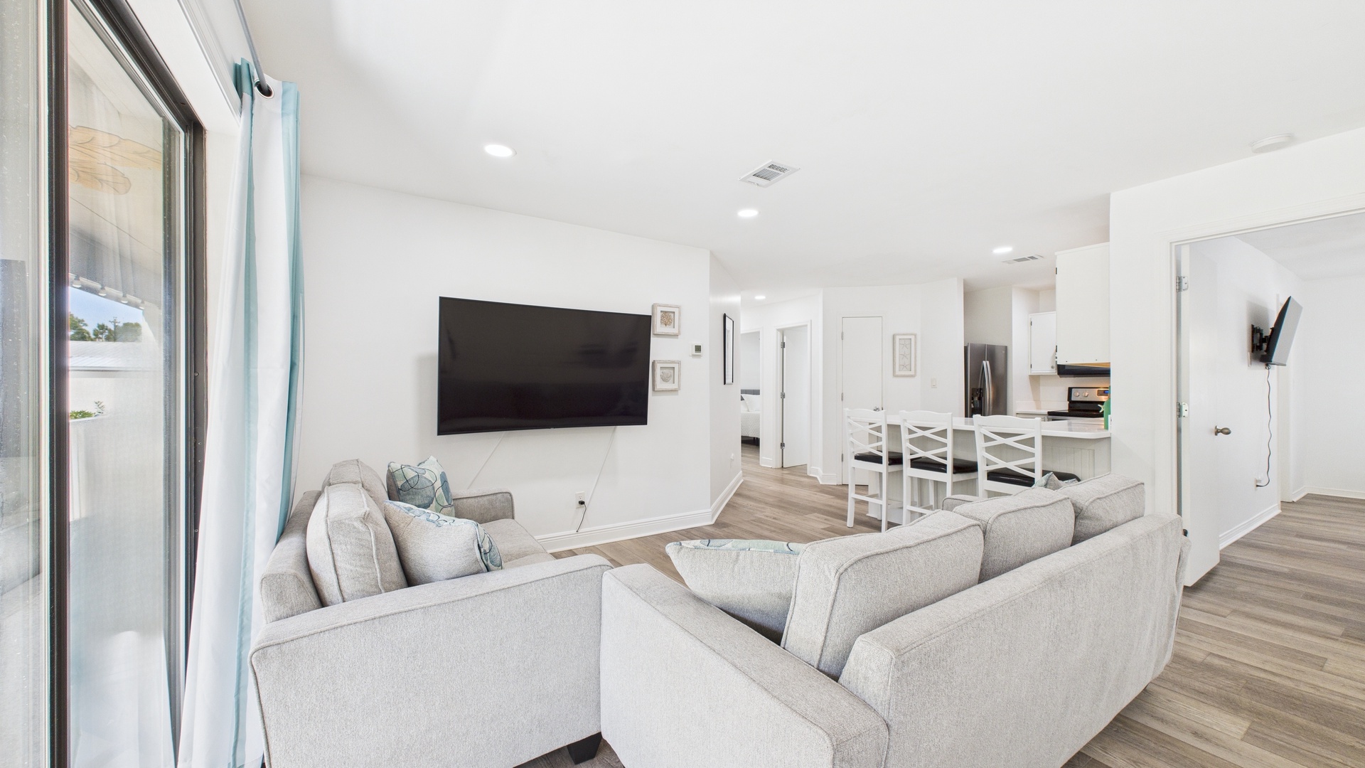 Open concept living area with huge TV and sleeper sofa