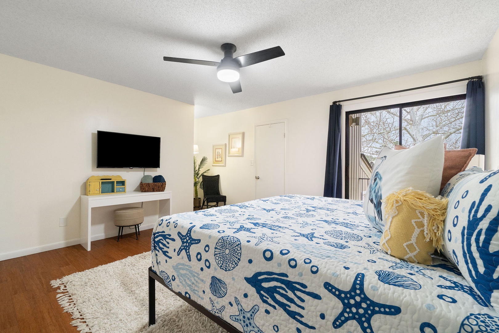 Primary bedroom with king bed TV and balcony access