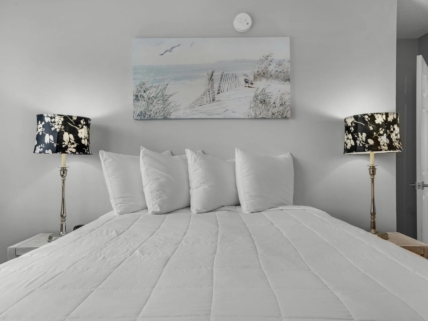 Second bedroom with queen bed, vanity table, and TV.