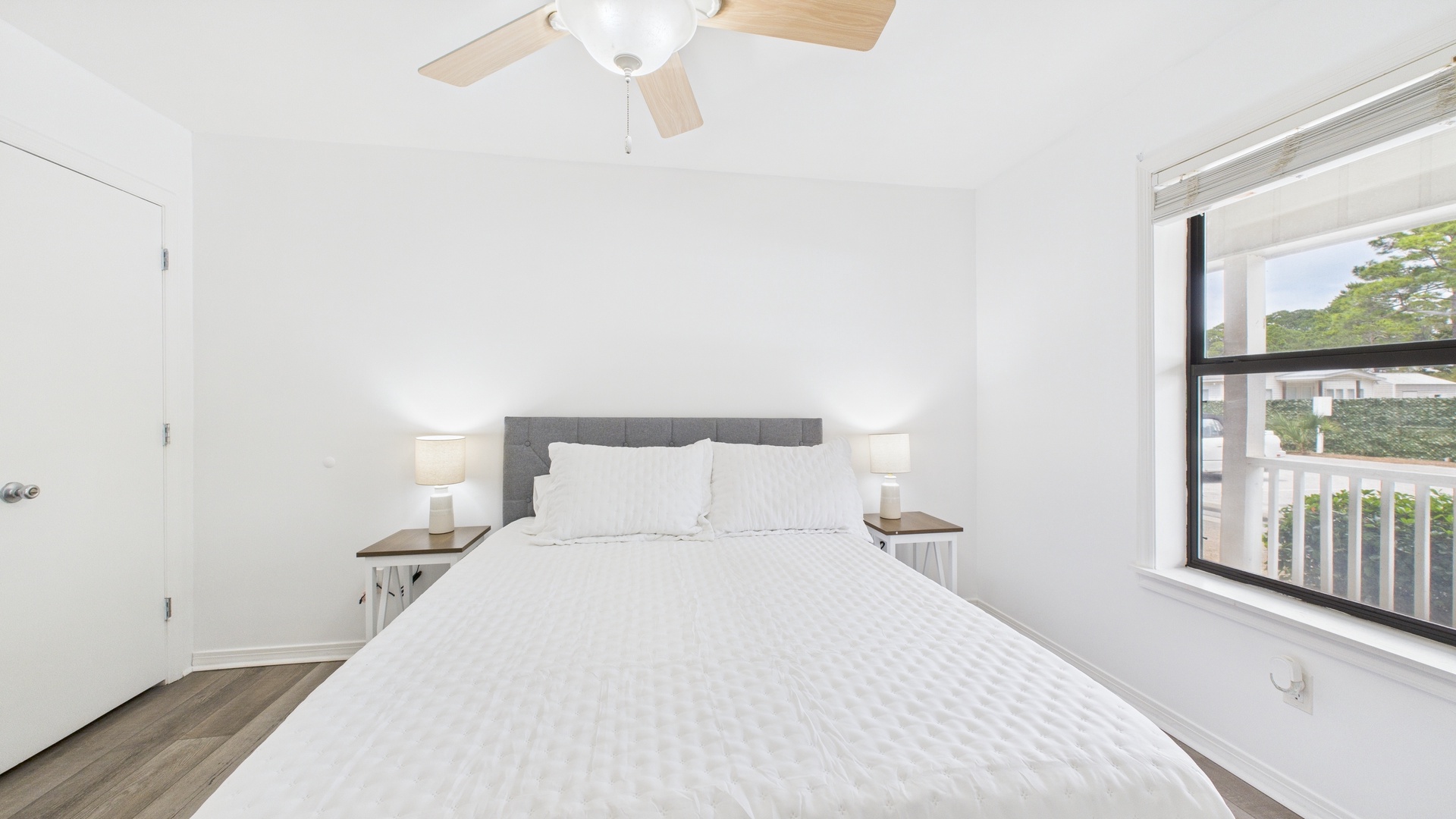 Guest bedroom with queen bed TV and balcony access