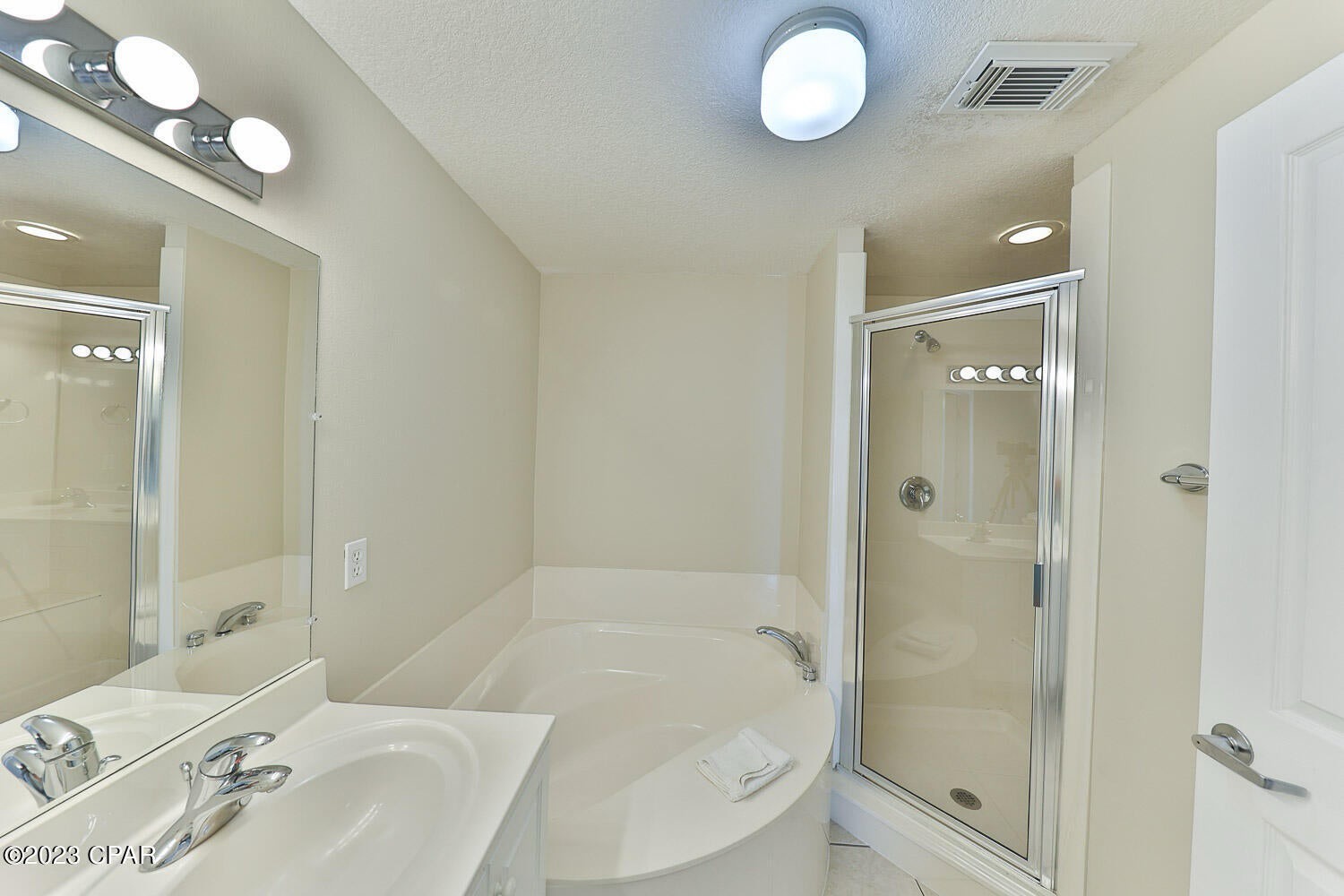 Primary bathroom with dual vanity bathtub and walk in shower