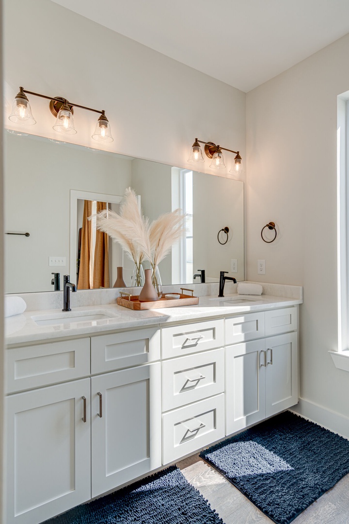 Primary bathroom with dual vanities and stand-in shower.