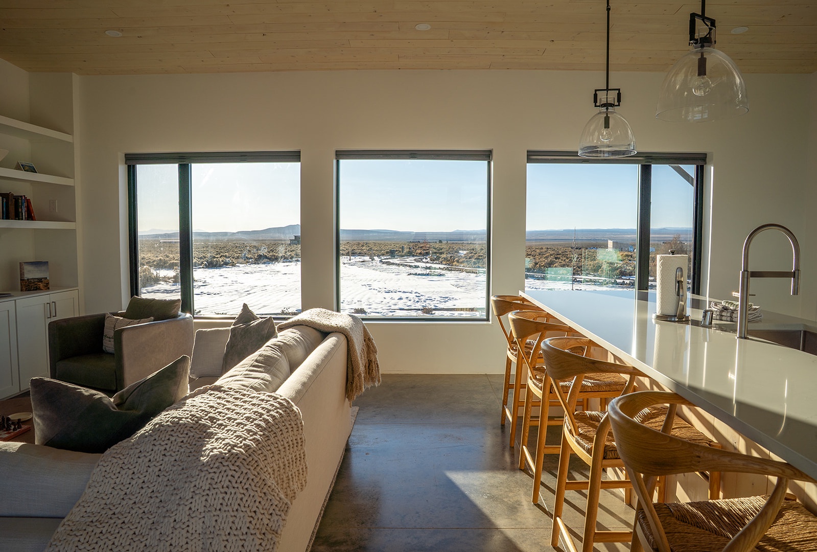 Soak in stunning desert views from your bright, modern living space with floor-to-ceiling windows and sleek kitchen island.
