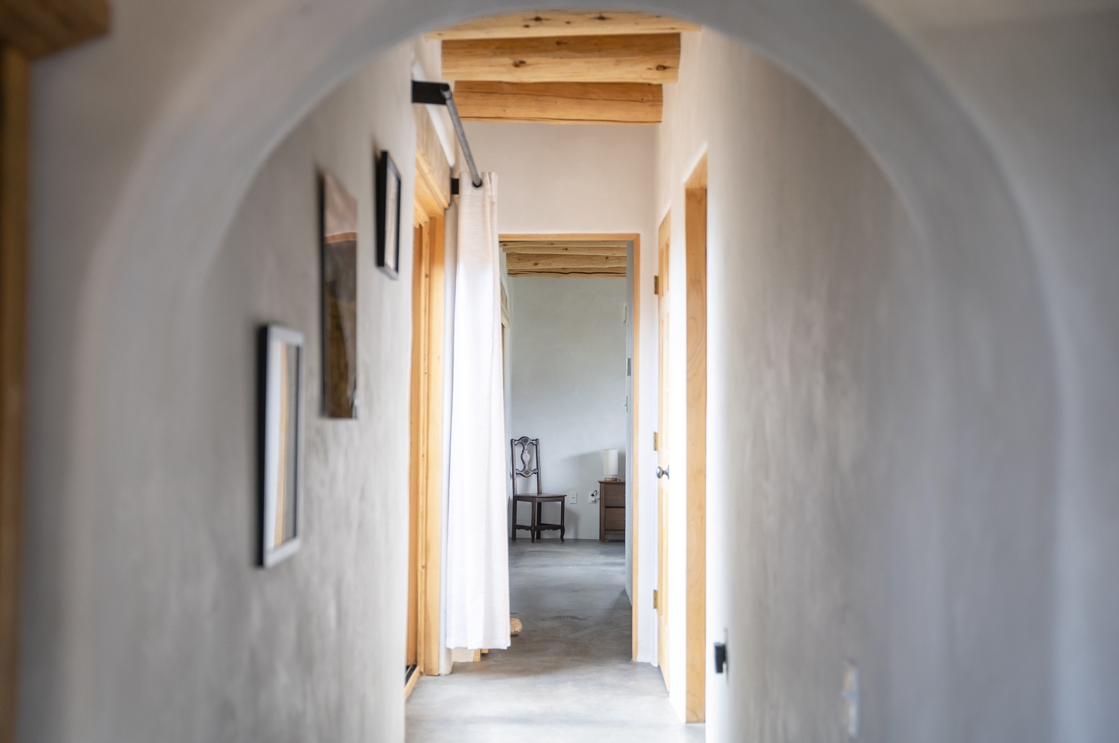 A serene hallway welcomes you with warm wood accents and soft archways, creating a peaceful transition between your private spaces.