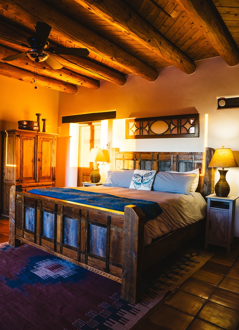 Unwind in this rustic bedroom where warm wooden beams and handcrafted furniture create your perfect southwestern retreat.