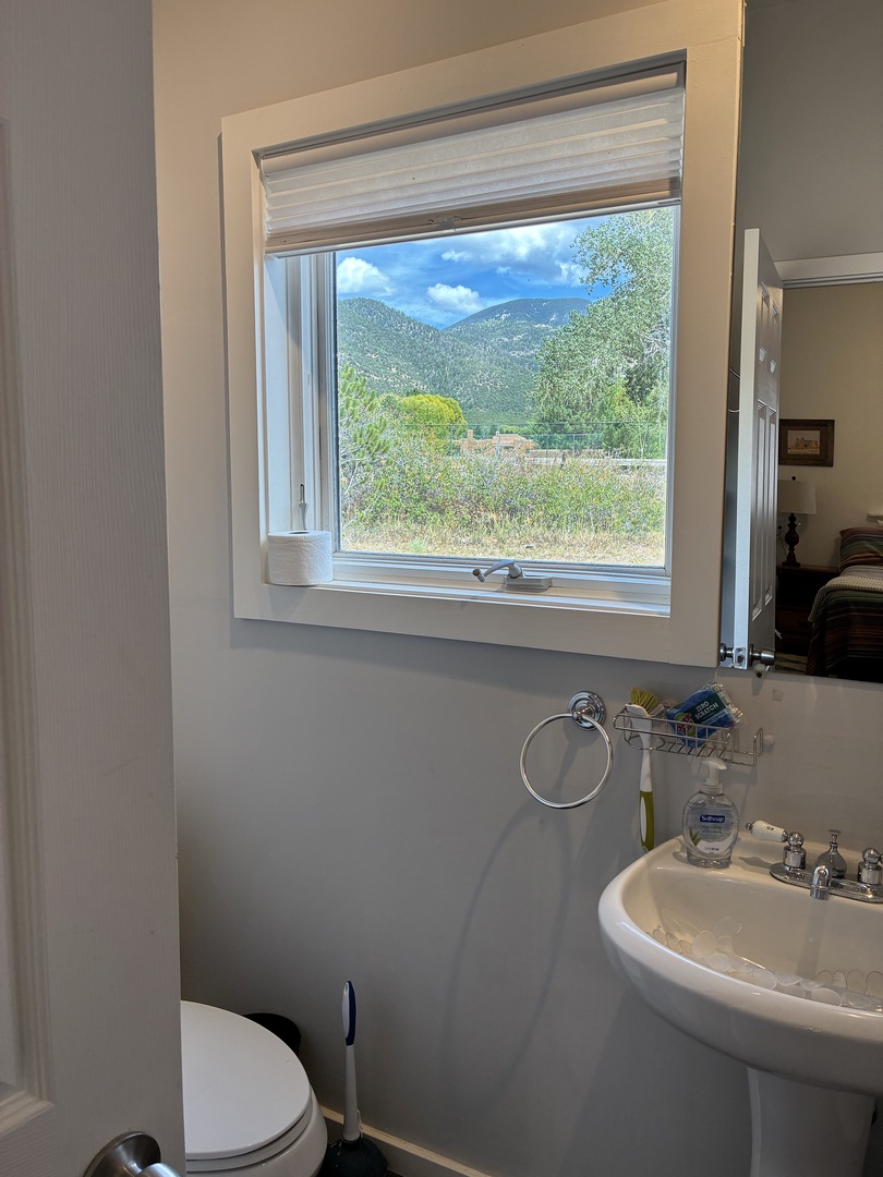 Refresh in your bright bathroom while gazing at stunning mountain scenery through the window—a serene view that makes every moment feel like an escape.