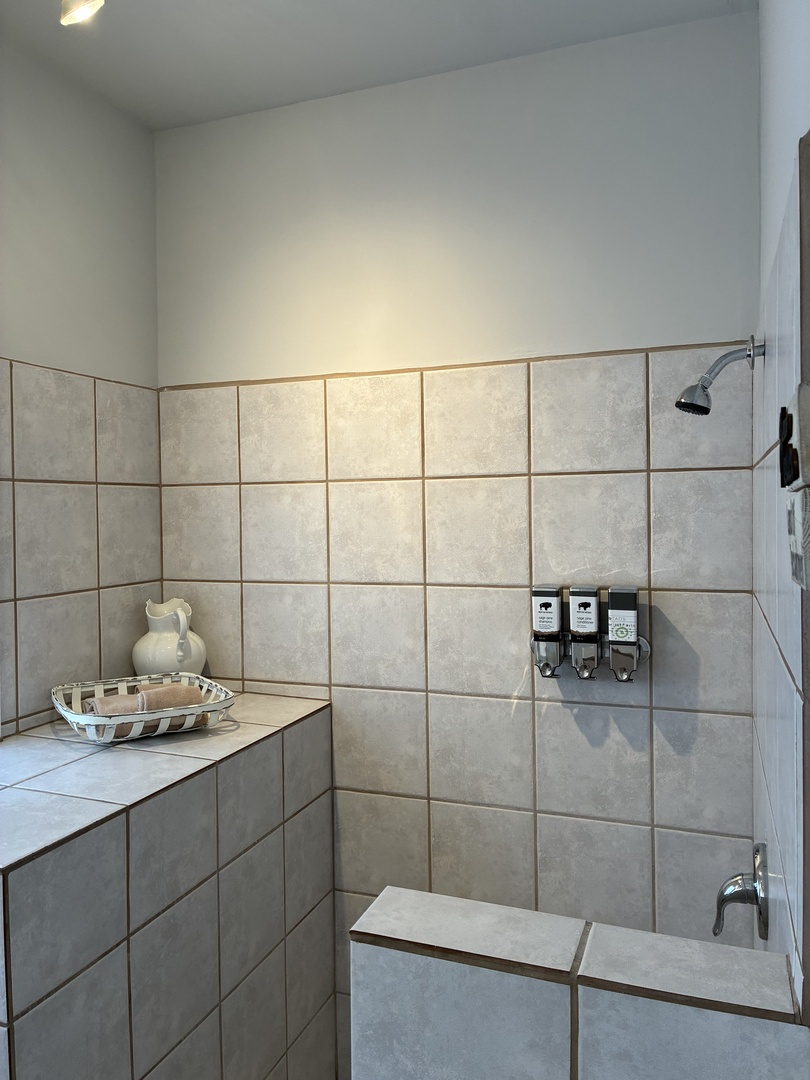 Step into your spa-like sanctuary where soft neutral tones and oversized tiles create a calming retreat. Fresh linens await while premium amenities promise a rejuvenating start to each day.