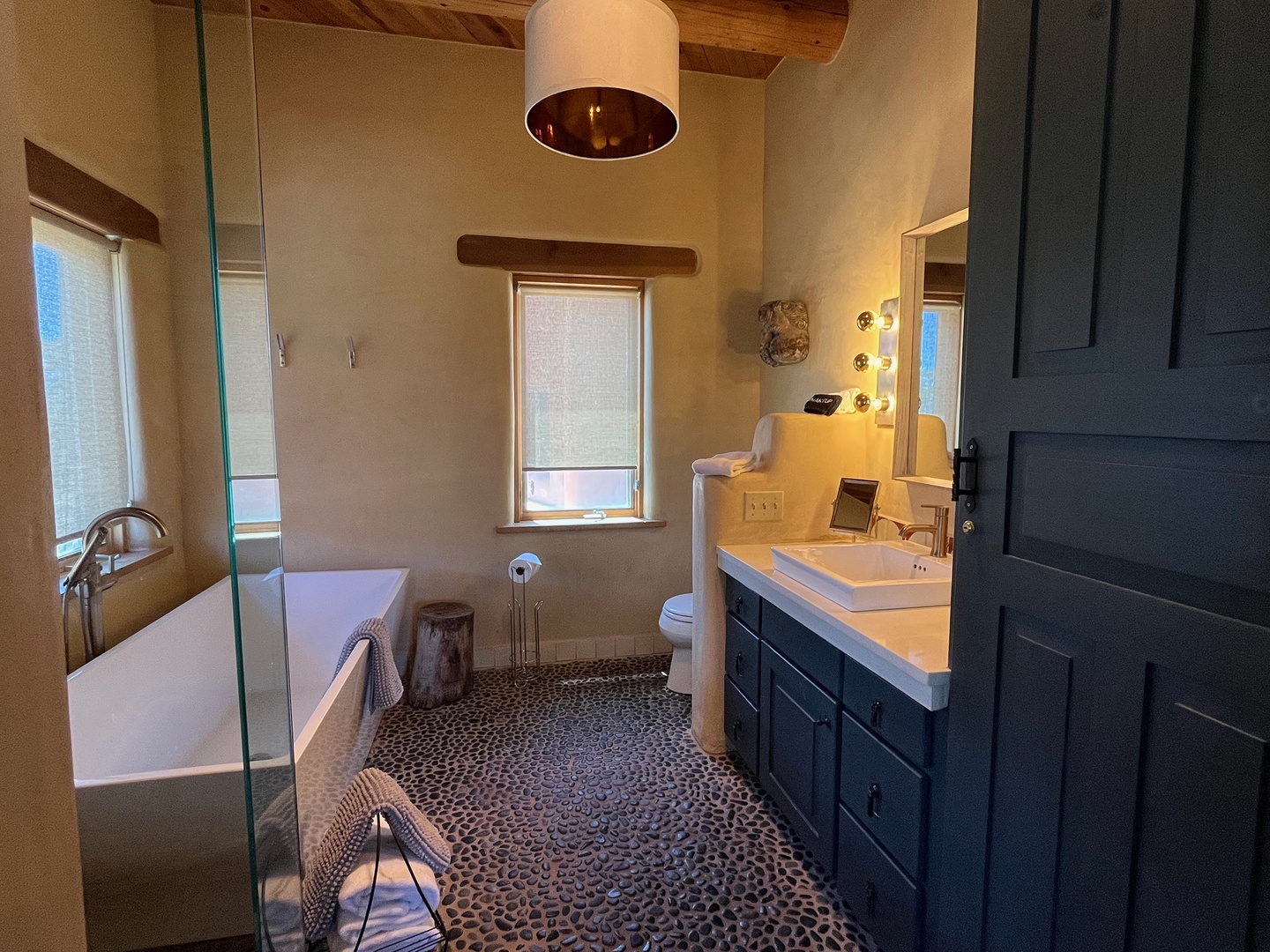 Step into your private spa-like sanctuary with vaulted ceilings, a soaking tub, and elegant pebble floors.
