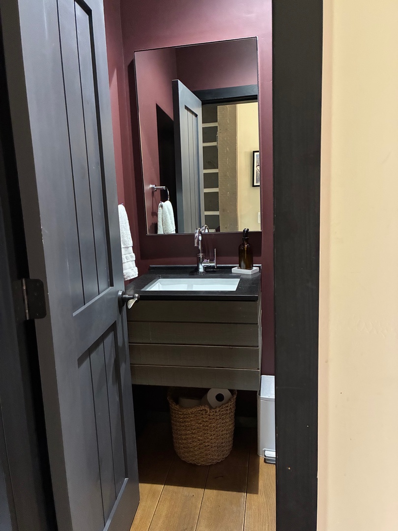 Step into your stylish powder room, where rich burgundy walls and a modern floating vanity create an intimate, boutique-like retreat for refreshing throughout your stay.