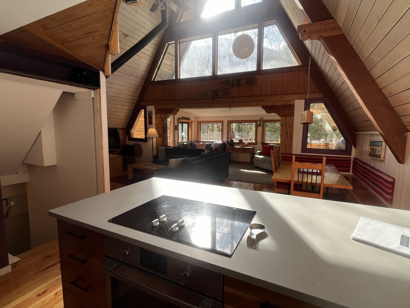 Sunlight streams through vaulted windows, illuminating your open-plan retreat where warm wood tones and a modern kitchen invite cozy mountain getaways.