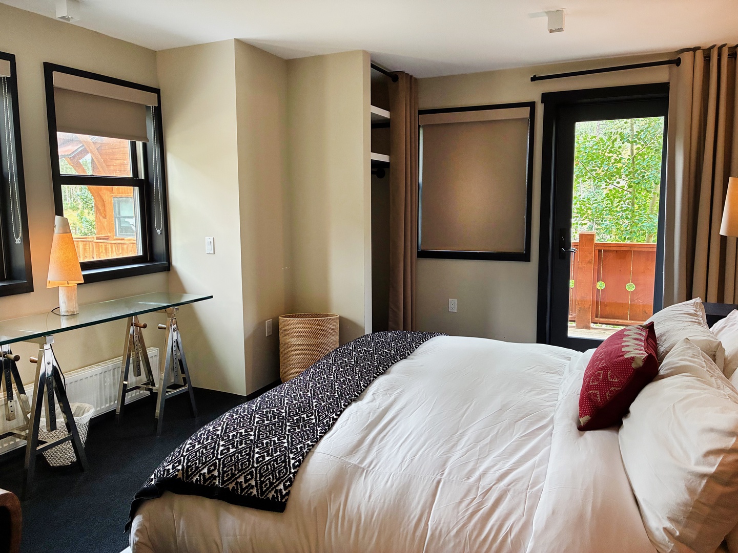 Step into your restful retreat with a plush bed layered in soft linens, warm natural light pouring through large windows, and a private balcony that invites you to unwind.