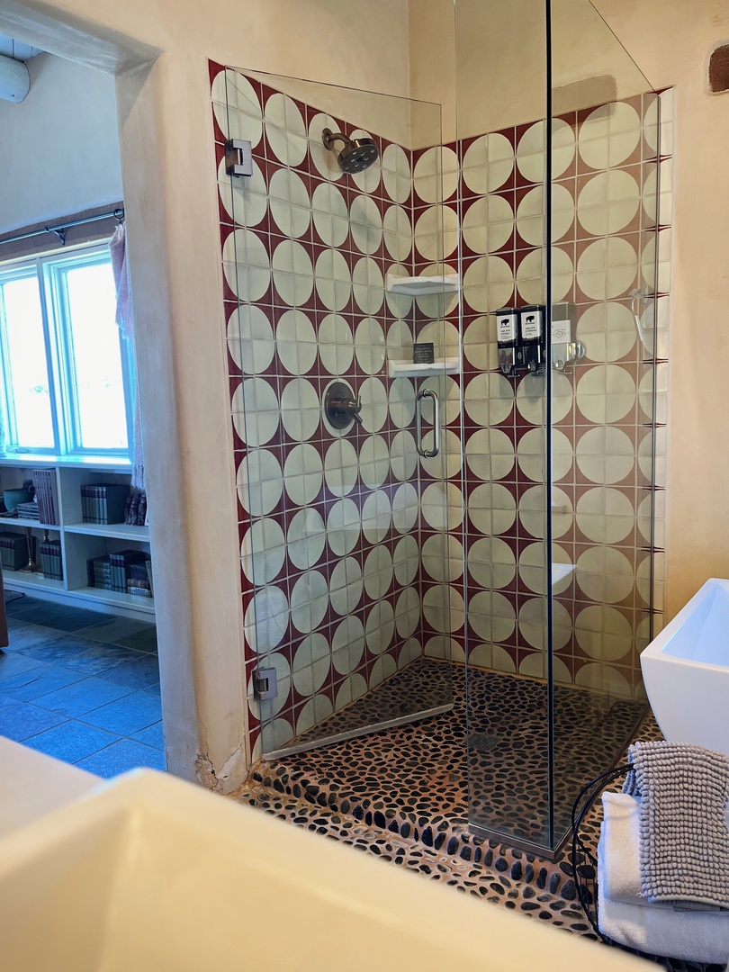 Walk in shower with geometric tile and glass surround