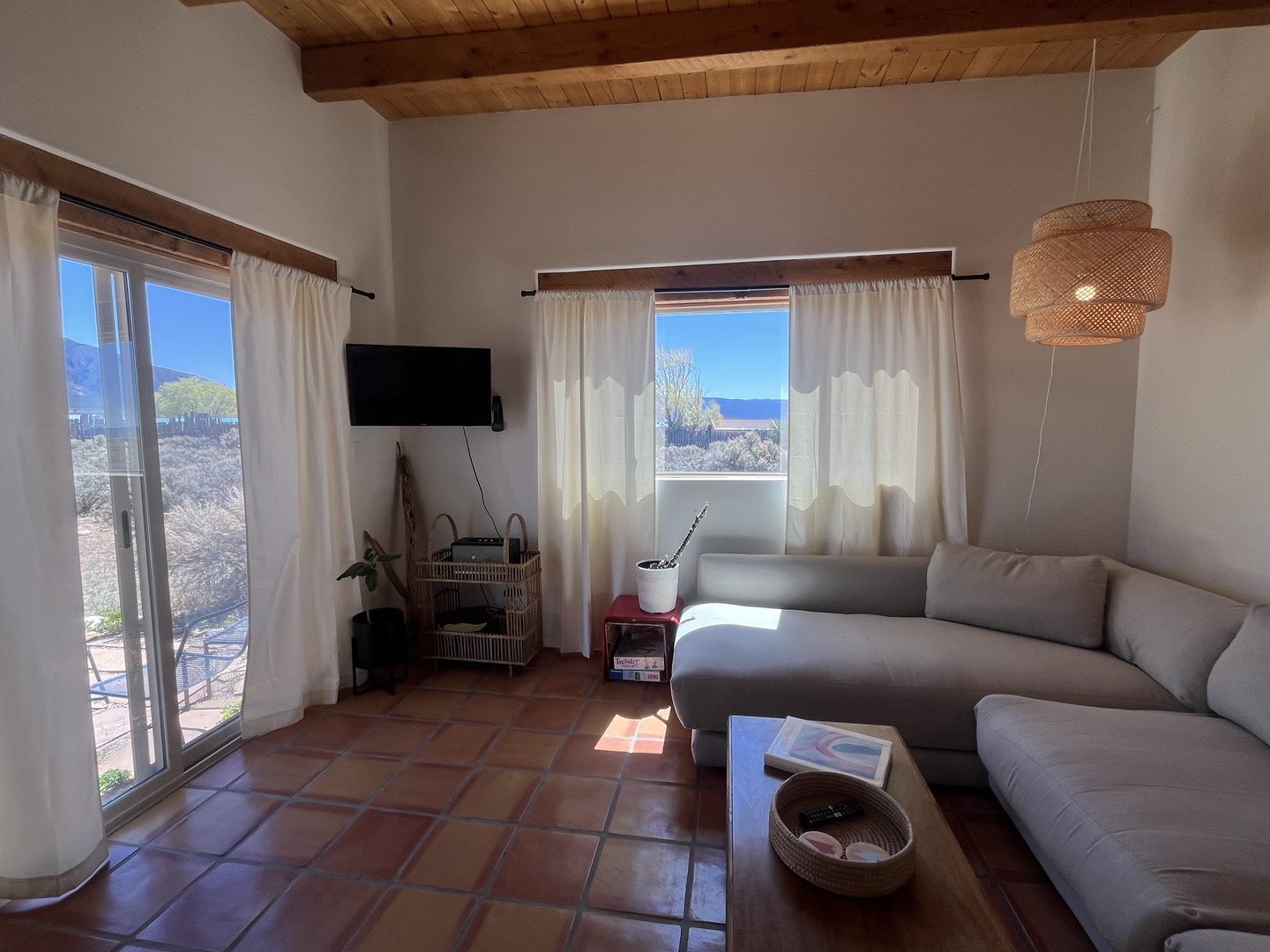 Unwind in your bright living room where warm wood beams frame stunning sea views, creating the perfect coastal retreat.