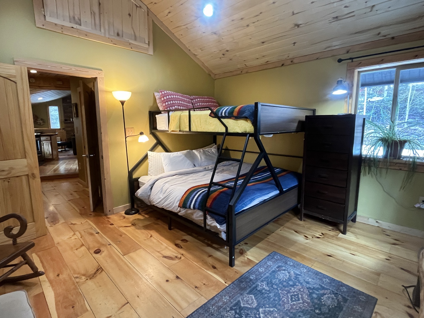 Cozy cabin bedroom with bunk beds perfect for family adventures, featuring rustic wood beams and warm natural light.