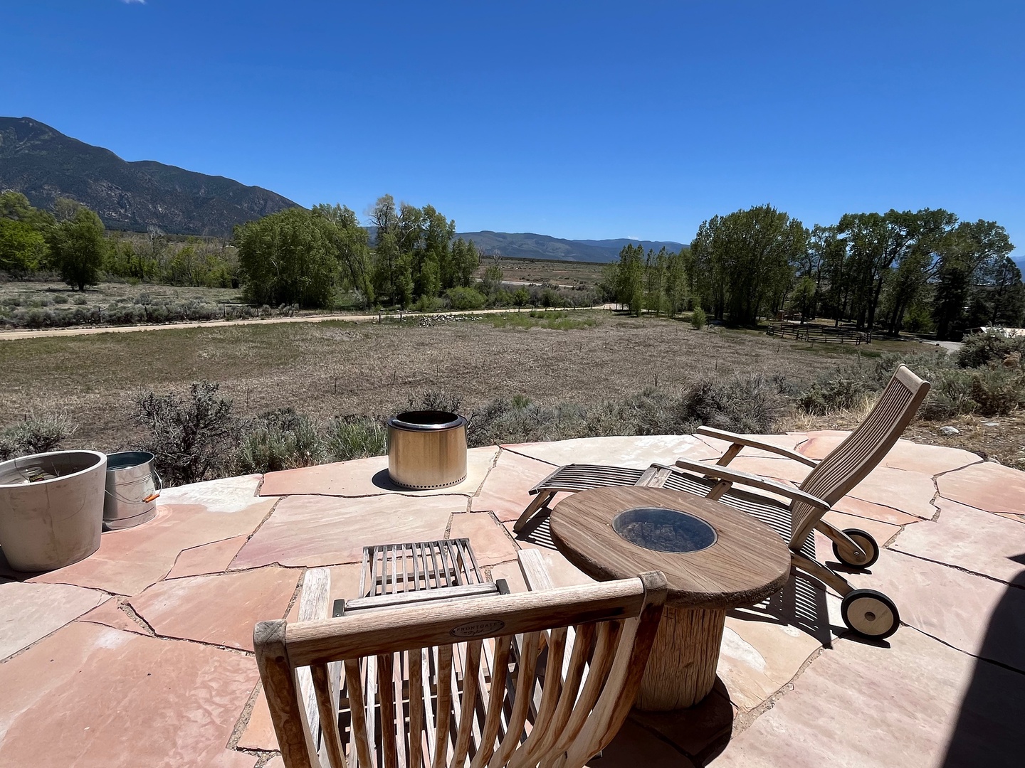 Great relaxing spot on the deck overlooking the fields below and Taos Pueblo beyond the trees