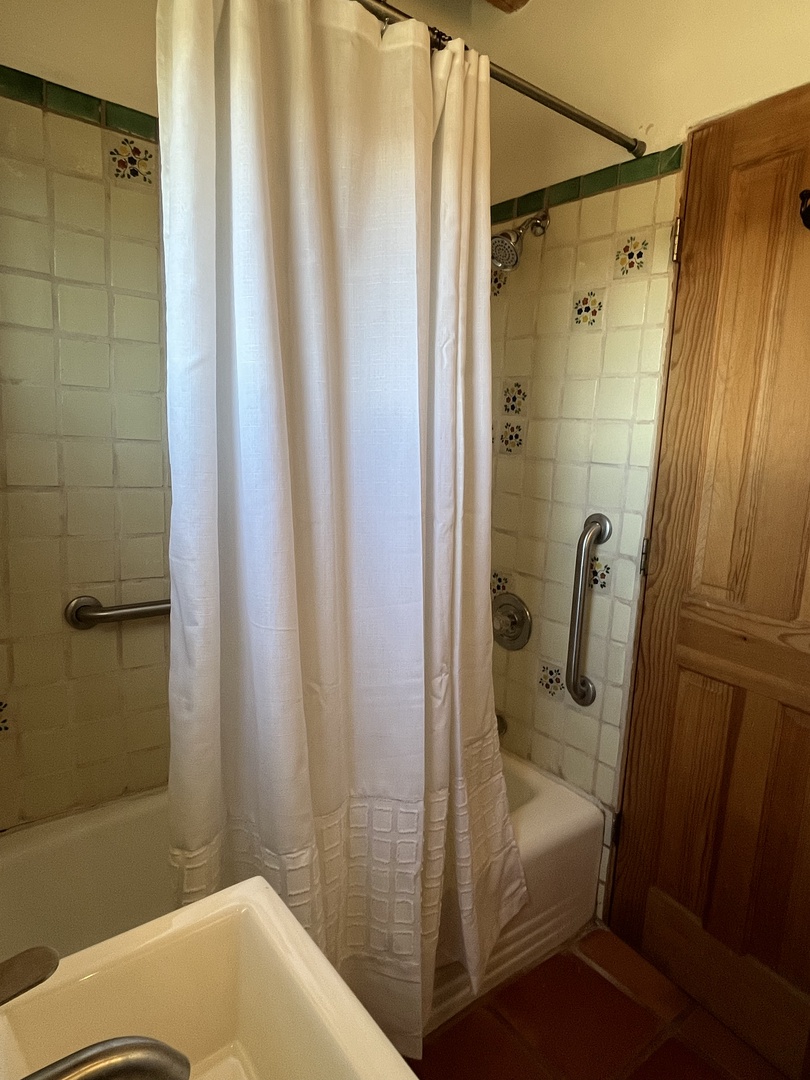 Step into your private bathroom with charming tile details and a refreshing shower-tub combo for a relaxing soak after your day.