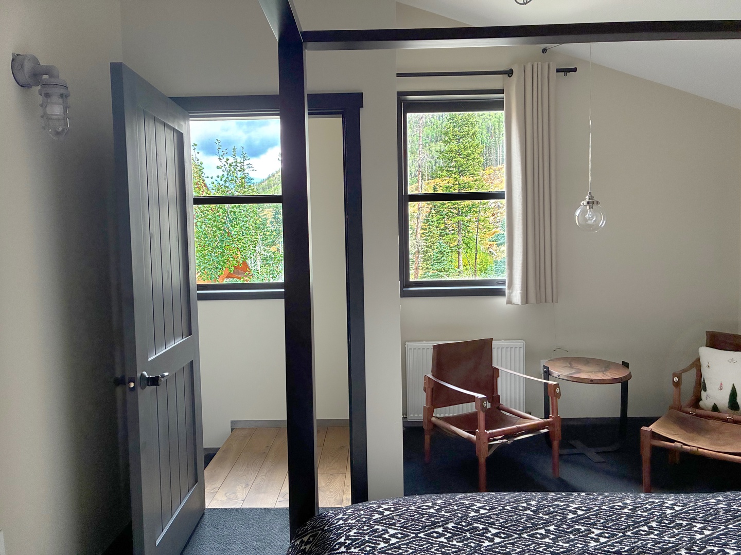 Step into your peaceful retreat with vaulted ceilings, warm natural light, and a cozy sitting nook by the window where you can unwind with serene forest views.