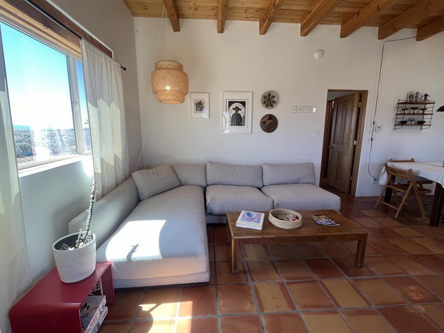 Relax in your bright, airy living room with natural wood beams and comfortable seating where morning light streams through windows.