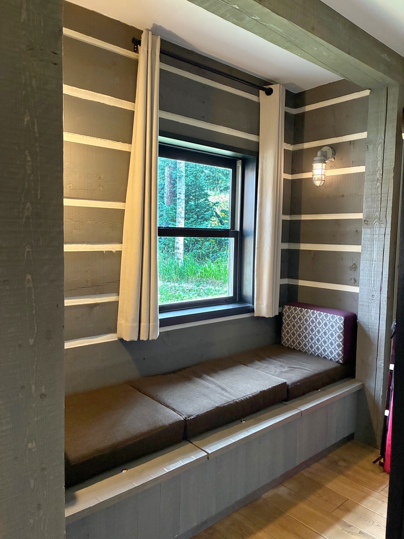 Your cozy window nook with open shelving invites you to curl up with a book and gaze out at the lush forest view just beyond the glass.