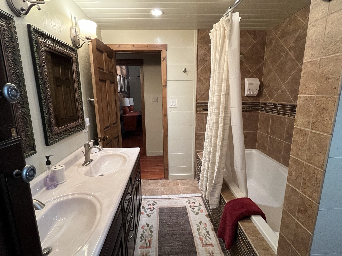 Upstairs queen bedroom bathroom vanity and tub, view across hall to bathroom