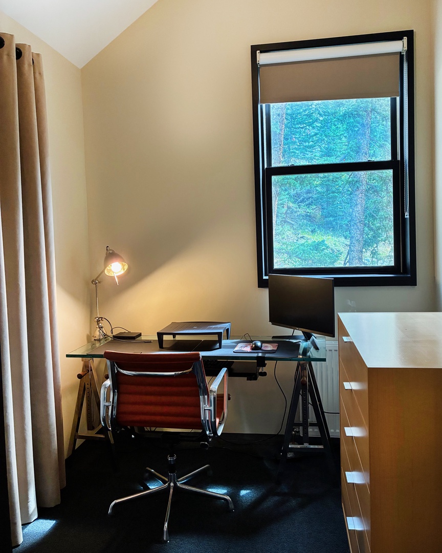 Set up your laptop at this sleek workspace, where soft natural light filters through the window and a cozy glow from the desk lamp helps you stay productive or plan your next adventure.