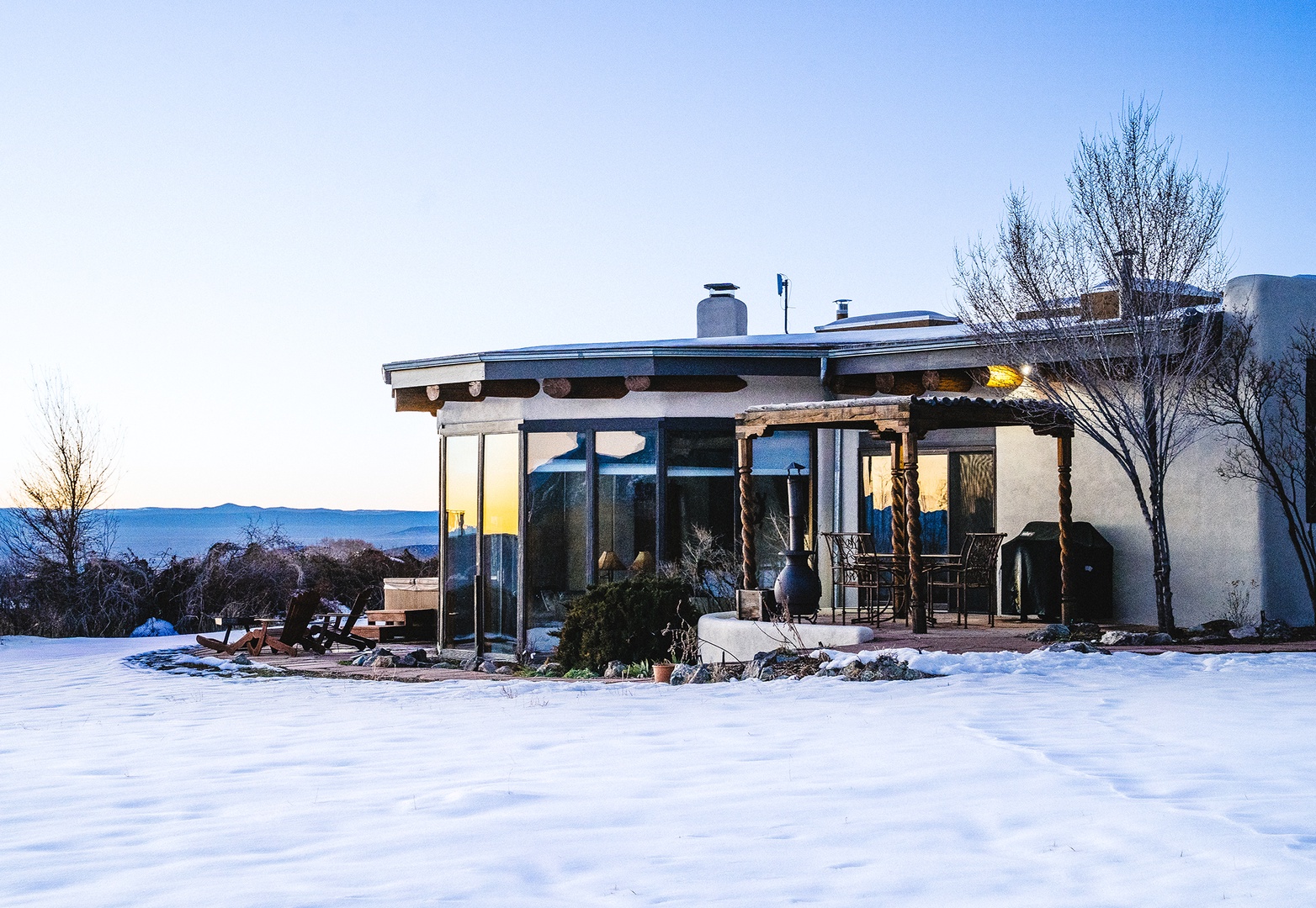 Modern retreat nestled in a pristine winter landscape with mountain views and snow-covered grounds.