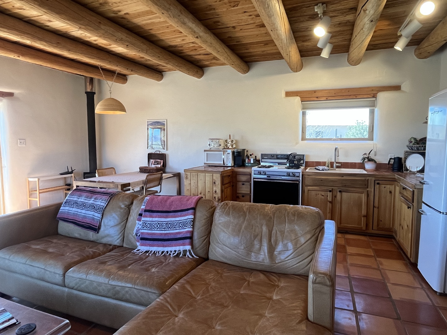 Relax in this inviting open-concept space where rustic wood beams meet modern comfort, perfect for cooking and unwinding together.