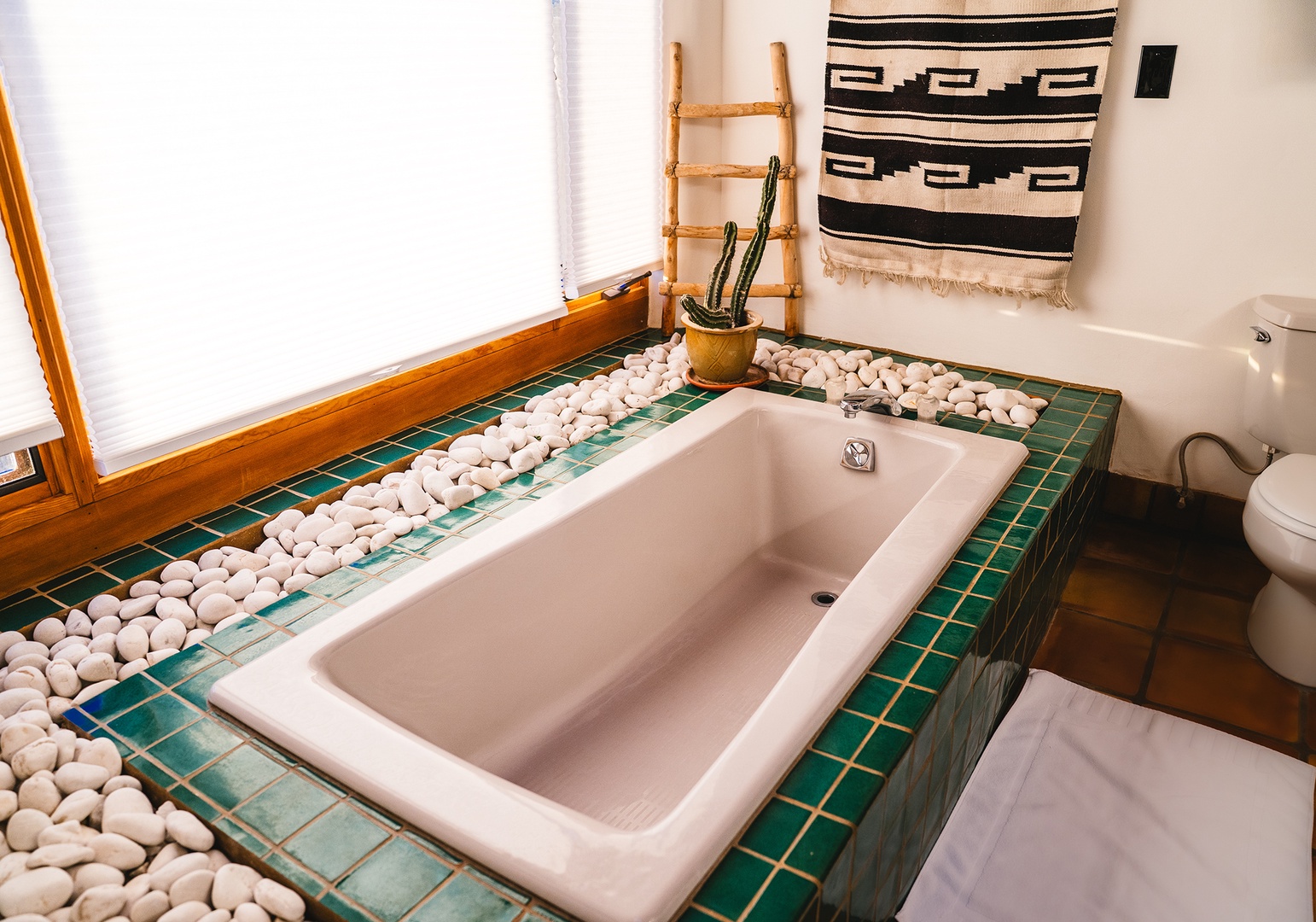 Soak in your private tiled spa tub surrounded by smooth river stones and southwestern charm for ultimate relaxation.