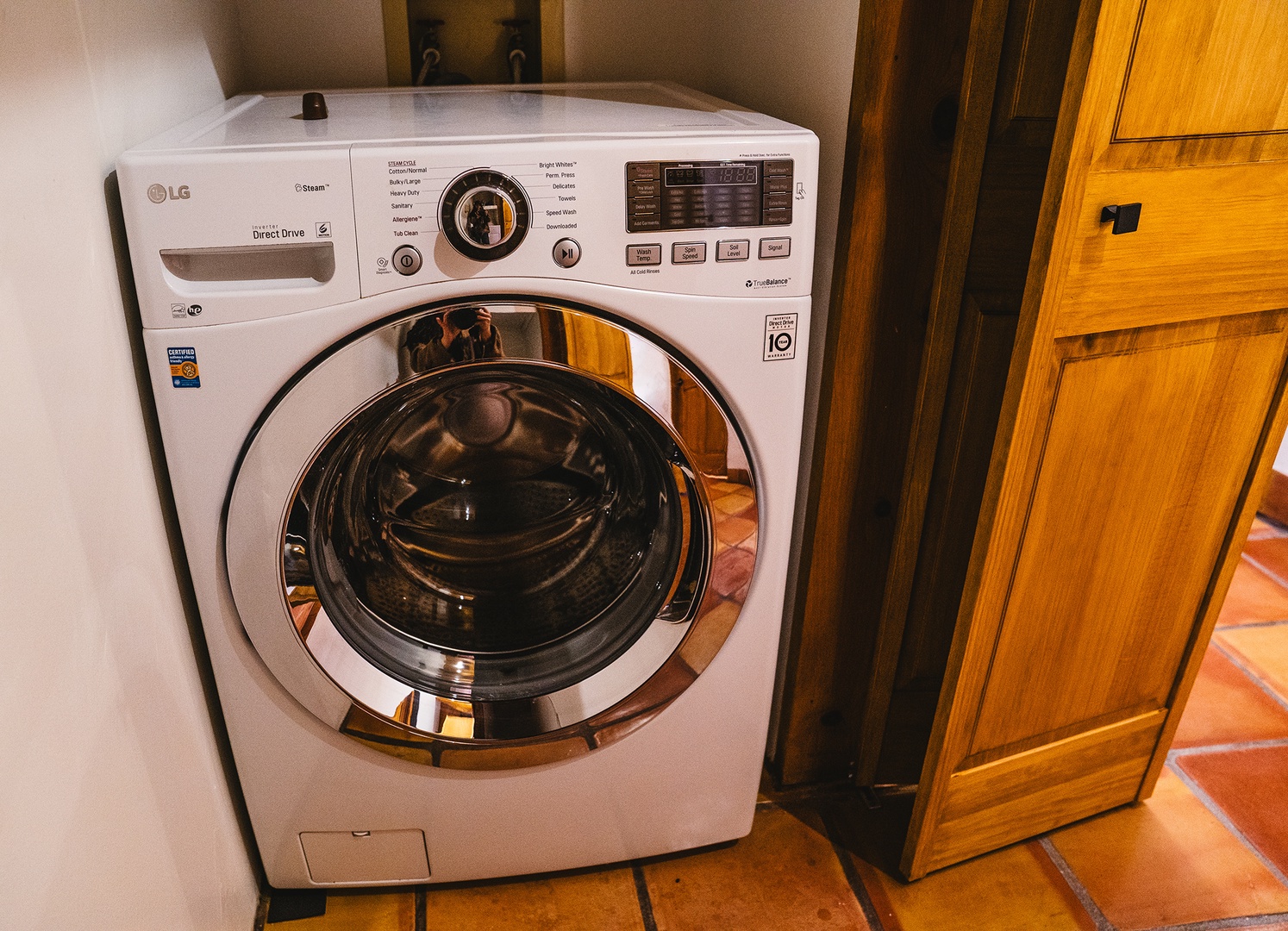 Fresh laundry at your fingertips with this modern LG washer, tucked conveniently into your warm wooden cabinetry for effortless convenience during your stay.