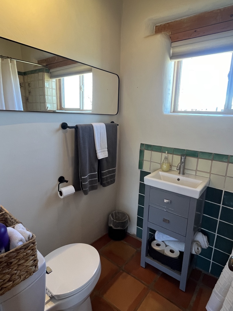 Refresh in your private bathroom with fresh towels, natural light, and thoughtful coastal-inspired tile details.