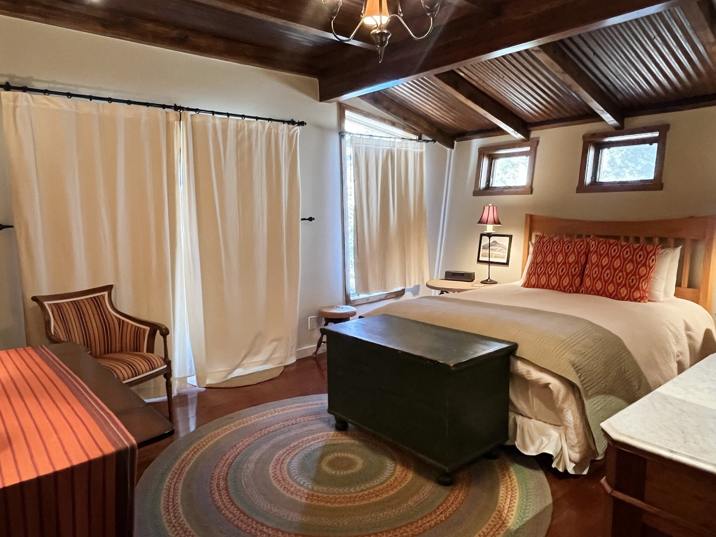 Primary main level queen bedroom with drawn curtains