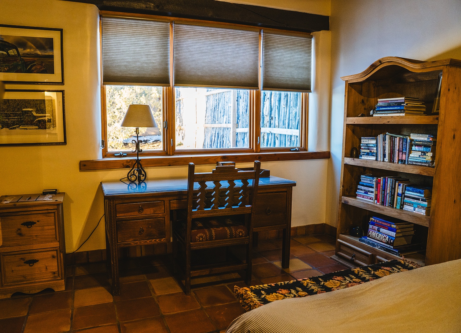 Your private workspace features a handcrafted desk by sunny windows, surrounded by books and warm southwestern charm for inspiring productivity.
