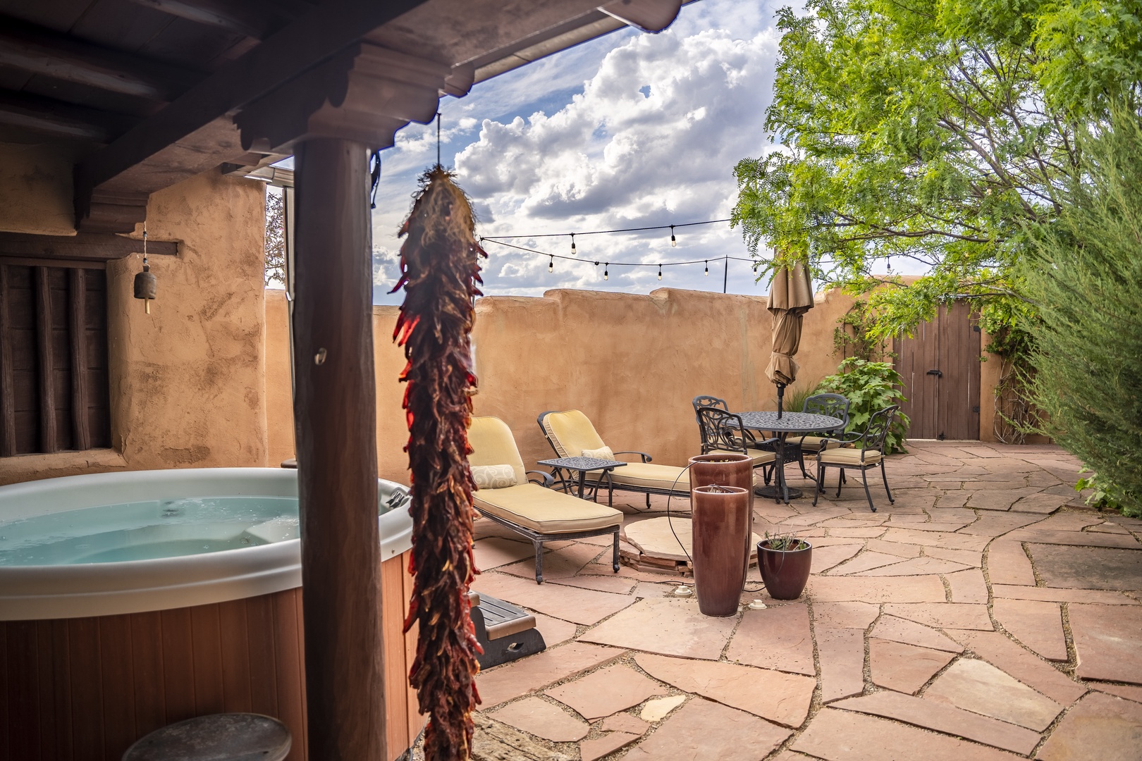Soak in your private hot tub under the Southwestern sky, surrounded by adobe walls and lush greenery—a serene retreat for complete relaxation.