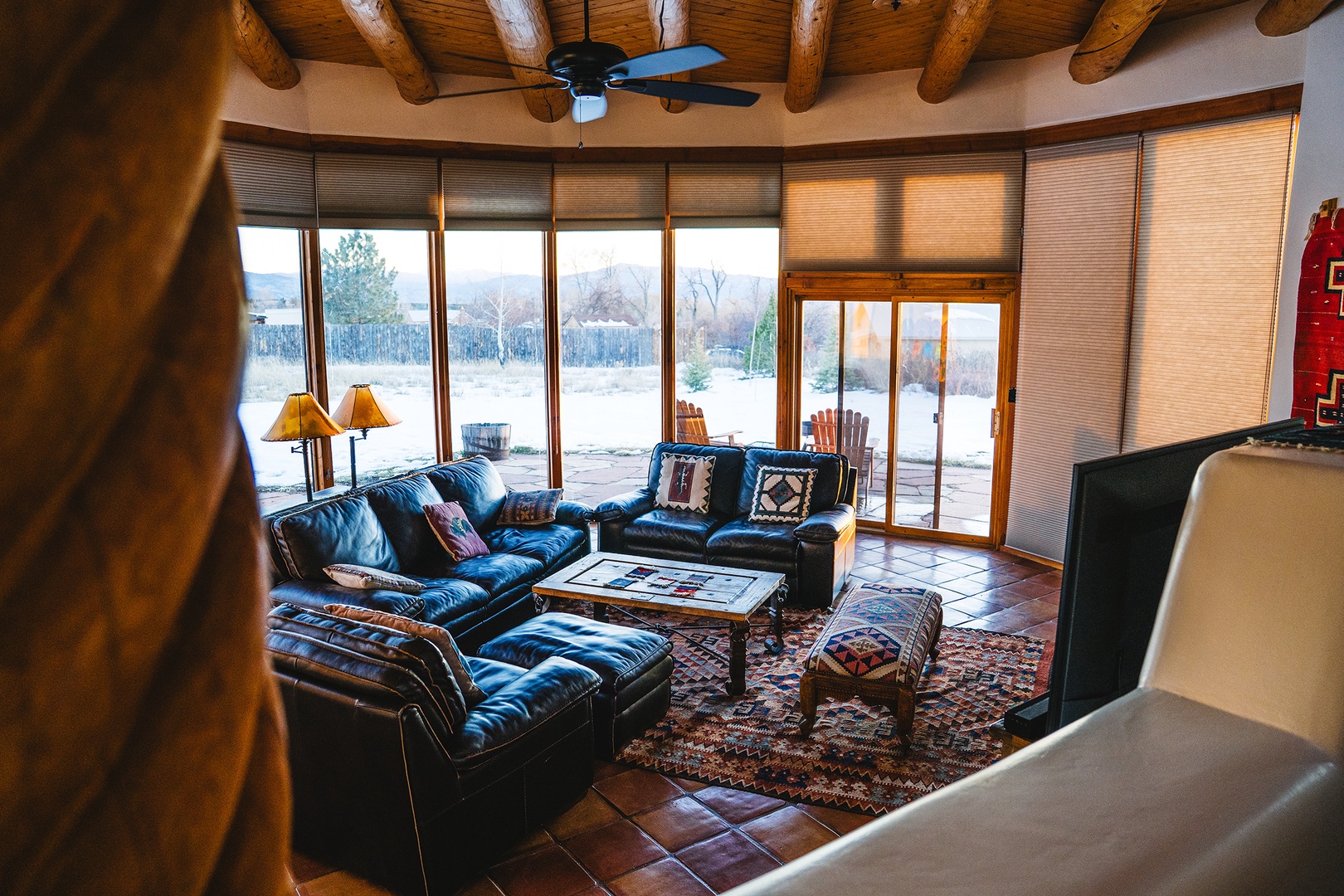 Sink into plush leather sofas beneath exposed wooden beams while gazing through floor-to-ceiling windows at serene winter landscapes.