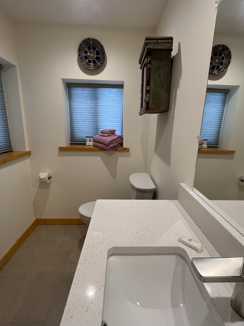 Freshen up in your modern bathroom with crisp white finishes, natural light, and plush towels waiting for you. The thoughtful design and clean lines create a serene space to unwind.