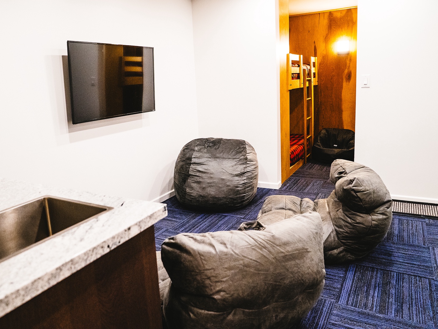 Bunk room and media area with bean bag chairs