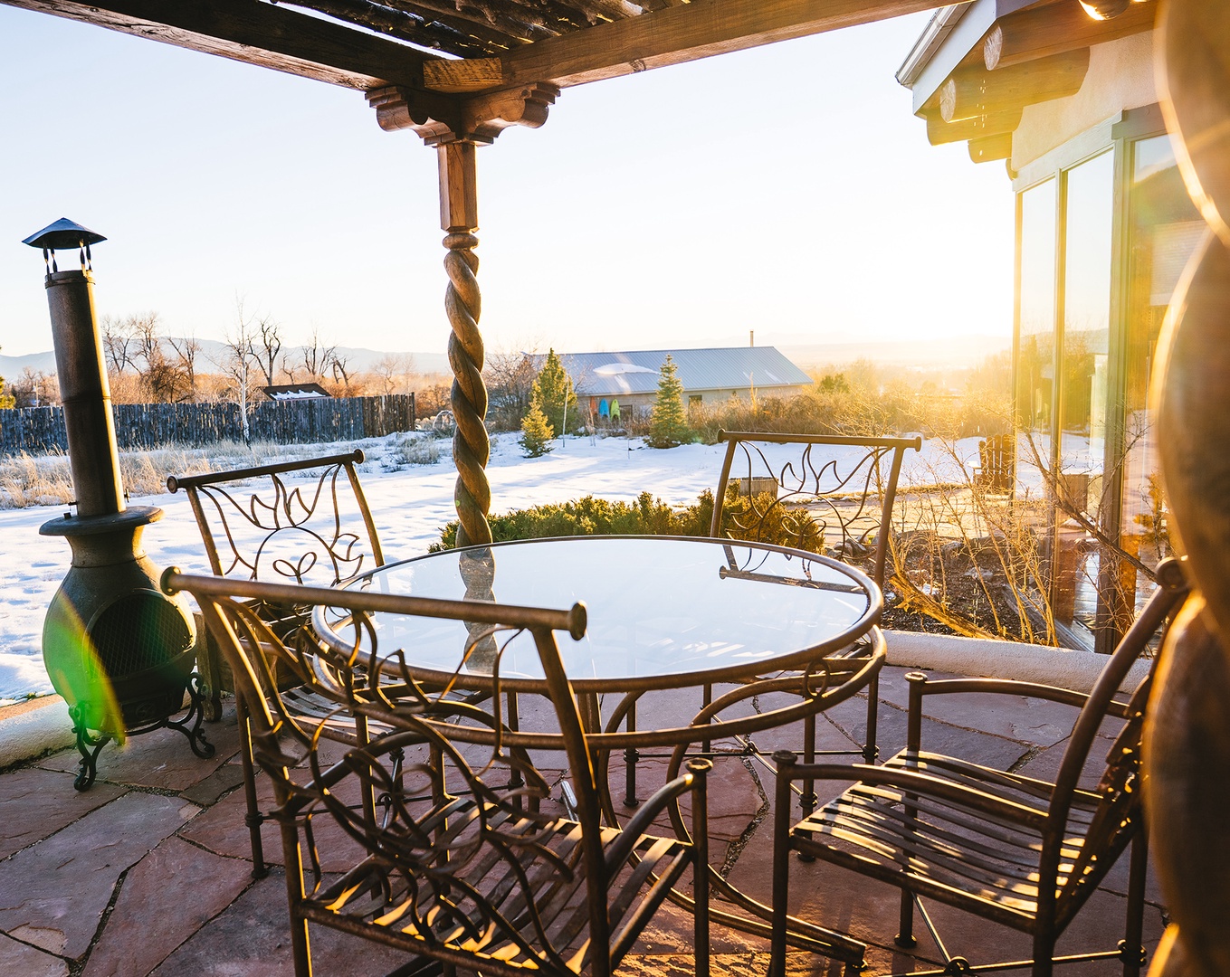 Enjoy morning coffee on your private patio as golden sunlight warms the space and snow sparkles across peaceful winter views.