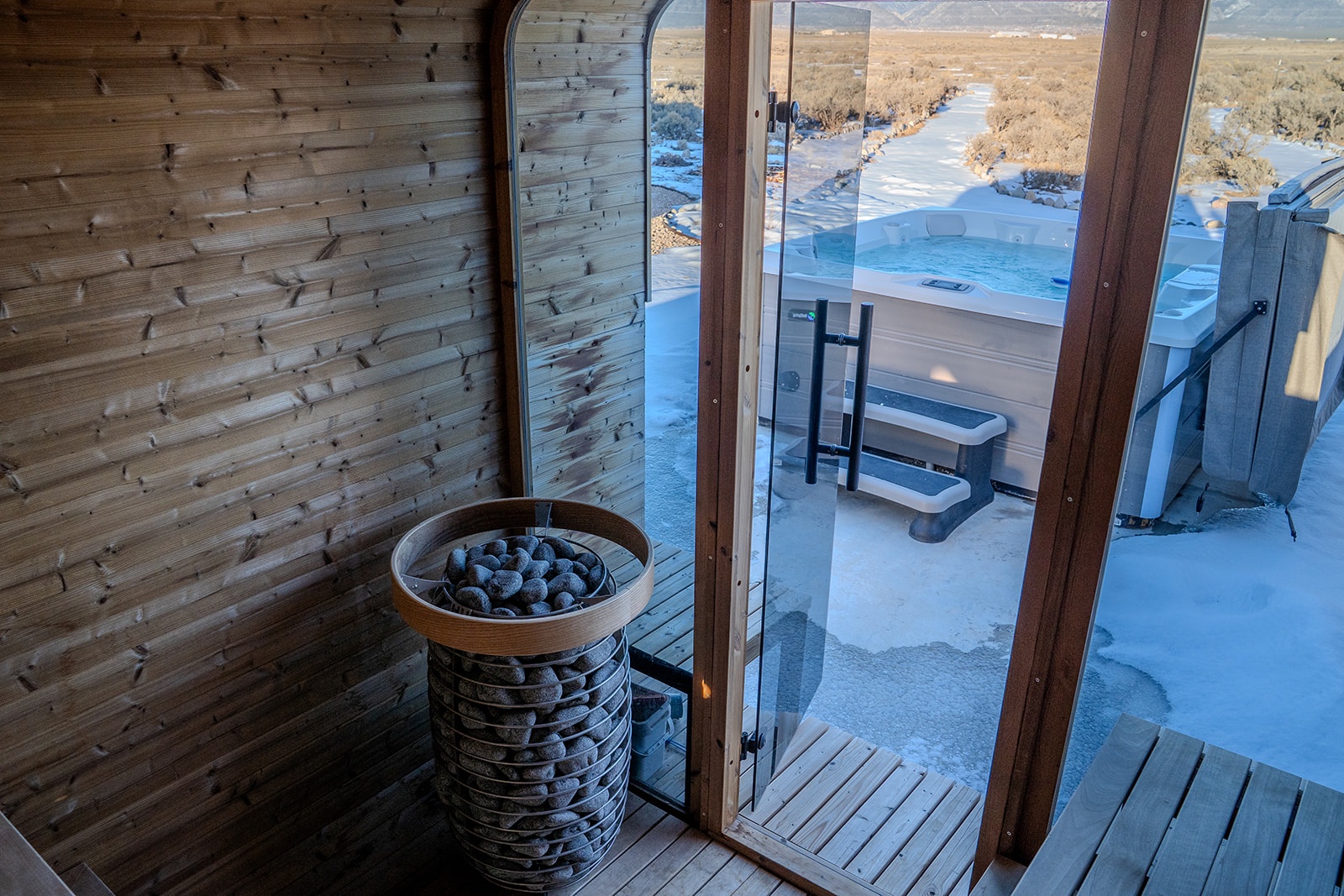 Unwind in your private sauna with traditional heated stones, then step onto the deck overlooking the serene landscape.