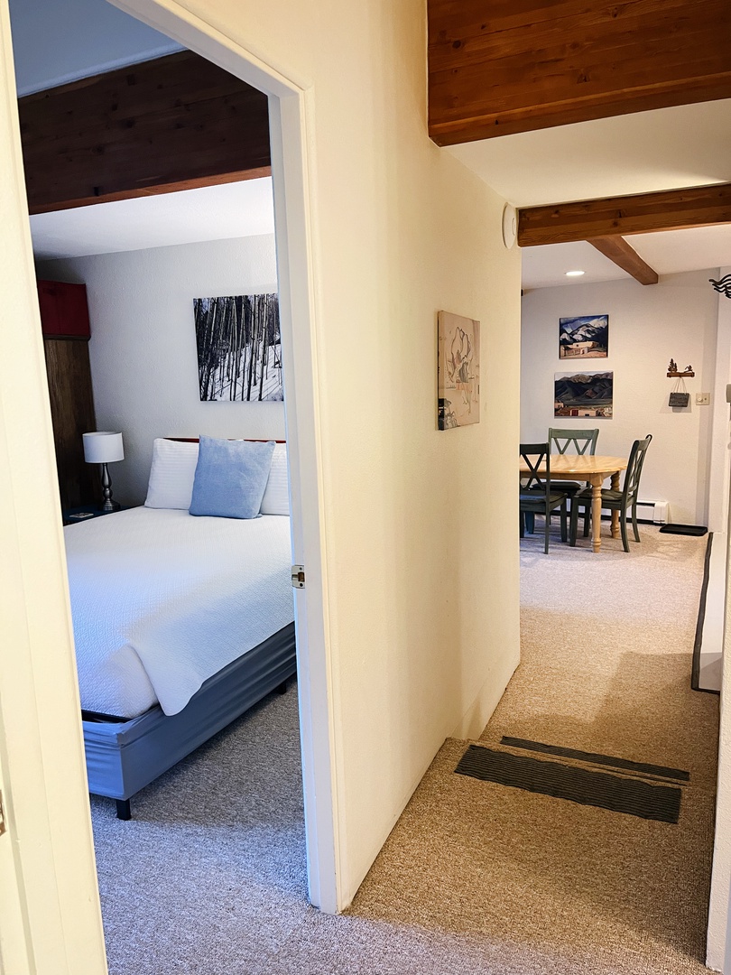 Hallway to living, dining, kitchen area and view into queen bedroom