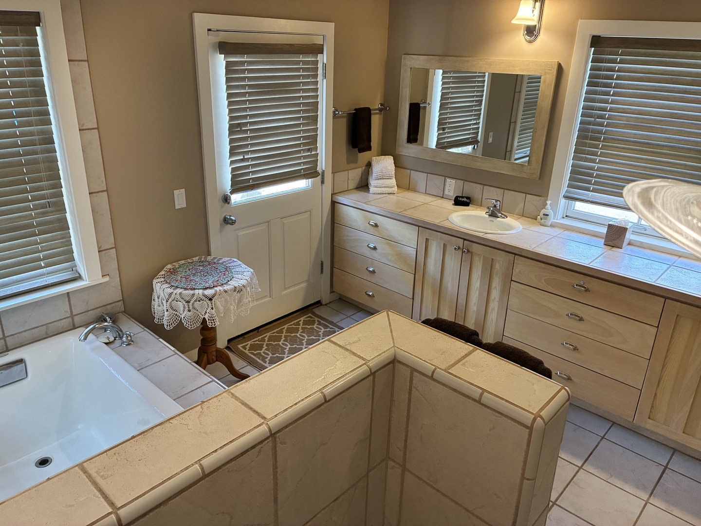 Step into your private spa-like retreat with a soaking tub, spacious vanity, and soft natural light—the perfect place to unwind after a day of exploring.