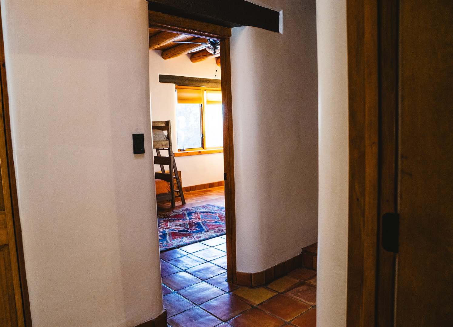 Step into your charming retreat where exposed wooden beams and traditional tile floors create authentic character throughout your cozy living space.