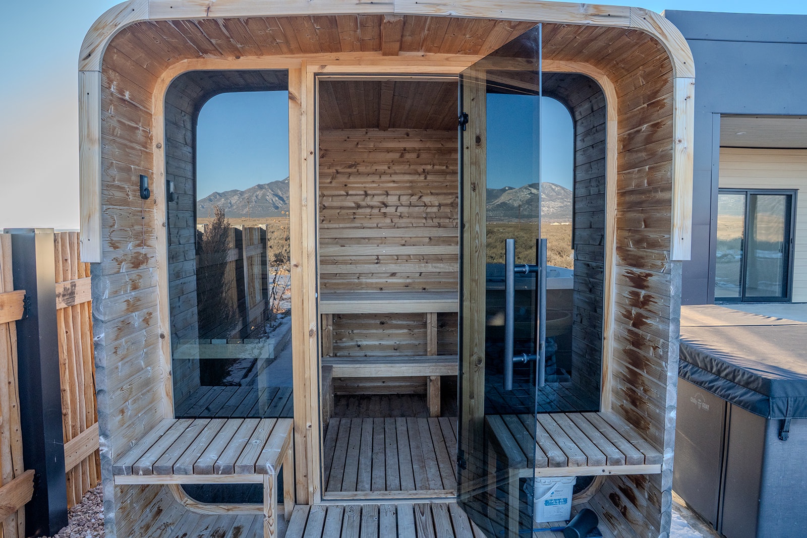 Unwind in your private cedar sauna with stunning mountain views through curved glass walls.